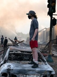 https://commons.wikimedia.org/wiki/File:A_man_stands_on_a_burned_out_car_on_Thursday_morning_as_fires_burn_behind_him_in_the_Lake_St_area_of_Minneapolis,_Minnesota_(49945886467).jpg